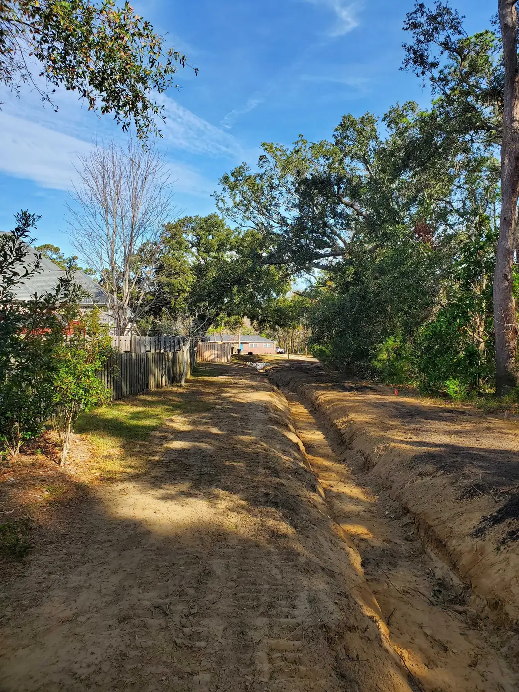 land grading cost in North Carolina, a drainage swale graded along a backyard fence line
