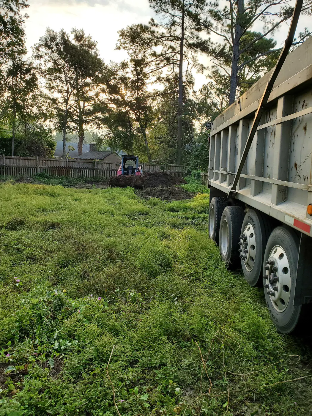 Dump truck working an overgrown field
