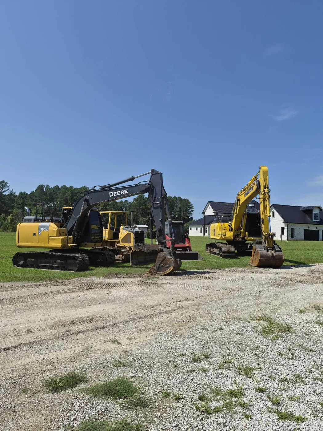 Excavators parked on a gravel yard