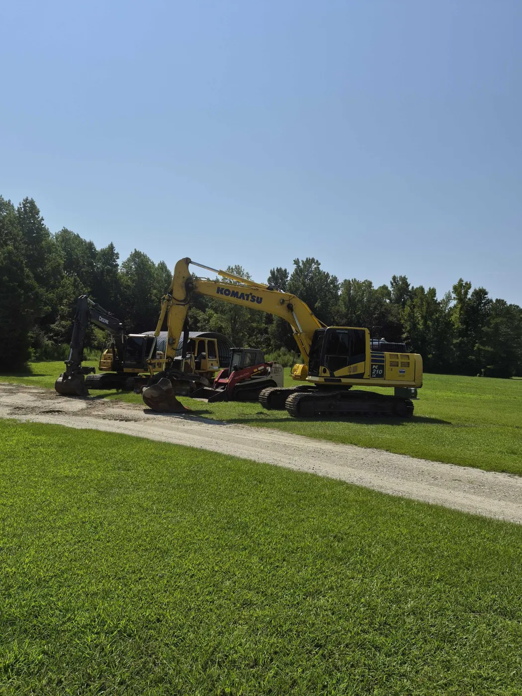 Two excavators staged on green grass