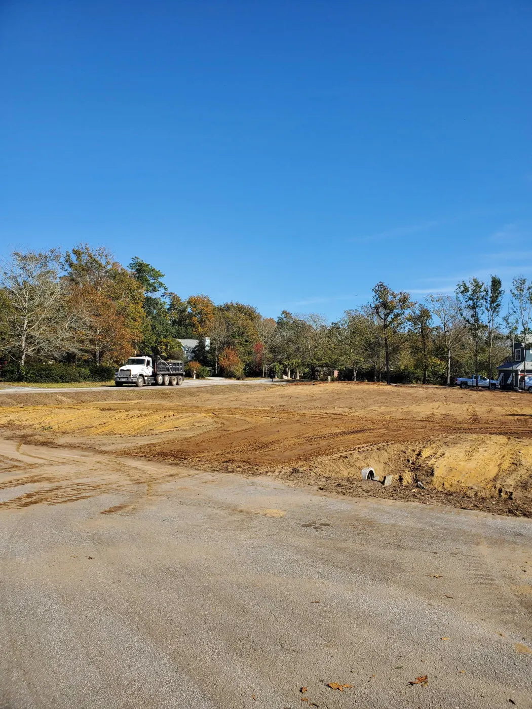 Dump truck loaded with demolition debris on a cleared Pender County property
