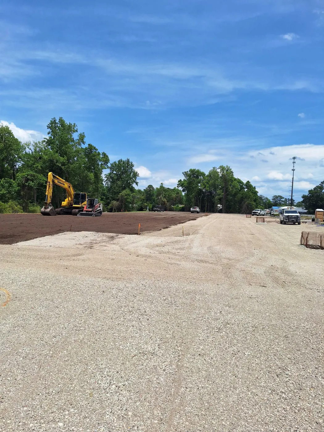 Excavator finishing a fresh gravel pad