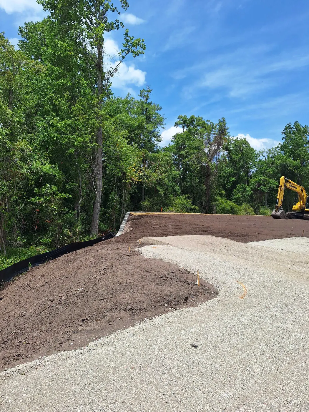 gravel driveway cost North Carolina, freshly built crushed stone driveway cut through pines on a rural Pender County lot